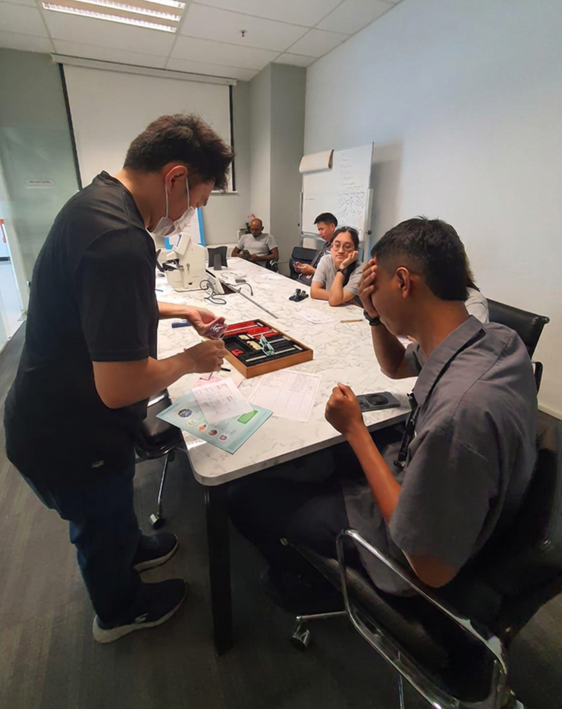 Lester conducting an on-site eye check for a worker at a Singapore workplace
